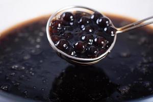 cocinar, hervir bolas de perla de tapioca con sabor a azúcar moreno, ingrediente de té de burbujas, preparar comida y bebida, primer plano, concepto de diseño de pasos de recetas. foto