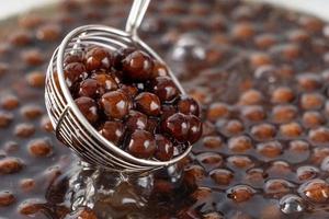 Cooking, boiling brown sugar flavor tapioca pearl balls, ingredient of bubble tea, preparing food and drink, close up, recipe cookbook steps design concept. photo