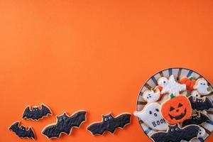 vista superior de las galletas de azúcar glas decoradas festivas de halloween sobre fondo naranja. foto