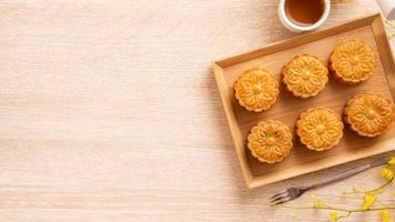 Mid-Autumn Festival holiday concept design of moon cake, mooncakes, tea set on bright wooden table with copy space, top view, flat lay, overhead shot photo
