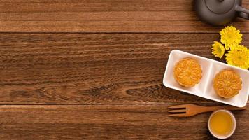 Moon cake for Mid-Autumn Festival, delicious beautiful fresh mooncake on a plate over dark wooden background table, top view, flat lay layout design concept. photo