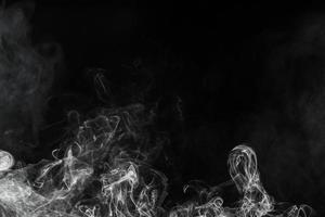 Conceptual image of white color smoke isolated on dark black background, Halloween design element concept. photo