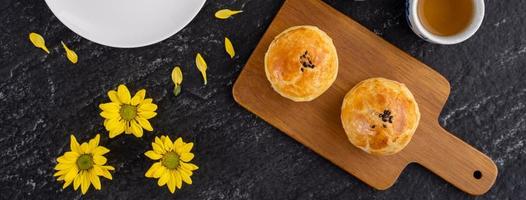 Moon cake yolk pastry, mooncake for Mid-Autumn Festival holiday, top view design concept on dark wooden table with copy space, flat lay, overhead shot photo