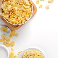Corn flakes bowl sweeties with milk and orange on white background, top view, flat lay overhead layout, fresh and healthy breakfast design concept. photo