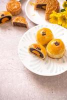 Tasty baked egg yolk pastry moon cake for Mid-Autumn Festival on bright wooden table background. Chinese festive food concept, close up, copy space. photo
