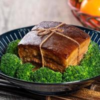 Dong Po Rou Dongpo pork meat in a beautiful blue plate with green broccoli vegetable, traditional festive food for Chinese new year cuisine meal, close up. photo