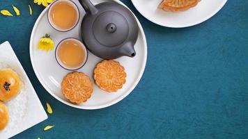 Moon cake for Mid-Autumn Festival, delicious beautiful fresh mooncake on a plate over blue background table, top view, flat lay layout design concept. photo