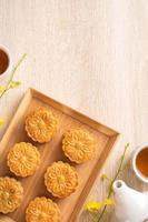 Mid-Autumn Festival holiday concept design of moon cake, mooncakes, tea set on bright wooden table with copy space, top view, flat lay, overhead shot photo