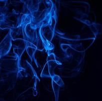 Conceptual image of blue color smoke isolated on dark black background, Halloween concept design element. photo