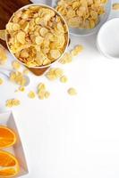 Top view of corn flakes bowl with milk on white background. photo