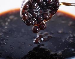 Cooking, boiling brown sugar flavor tapioca pearl balls, ingredient of bubble tea, preparing food and drink, close up, recipe cookbook steps design concept. photo