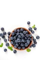 Blueberry fruit top view isolated on a white background, flat lay overhead layout with mint leaf, healthy design concept. photo