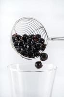 Making bubble tea, scoop and pour cooked brown sugar flavor tapioca pearl bubble balls into cup on white wooden table background, close up, copy space. photo