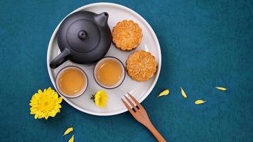 Moon cake for Mid-Autumn Festival, delicious beautiful fresh mooncake on a plate over blue background table, top view, flat lay layout design concept. photo