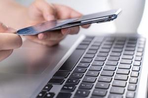 Office online paying, stay home shopping, electronic payment with credit card concept, laptop on white table background with shop cart, close up. photo