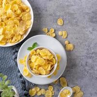 Corn flakes bowl sweets on gray cement background, top view flat lay layout design, fresh and healthy breakfast concept. photo