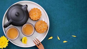 pastel de luna para el festival de mediados de otoño, delicioso y hermoso pastel de luna fresco en un plato sobre una mesa de fondo azul, vista superior, concepto de diseño plano. foto