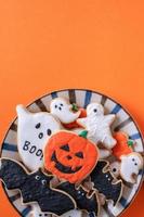 Top view of Halloween festive decorated icing sugar cookies on orange background. photo