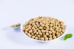 Yellow-green Taiwanese organic non-GMO soybeans, soy beans in a container isolated on white backgorund, close up, clipping path. photo