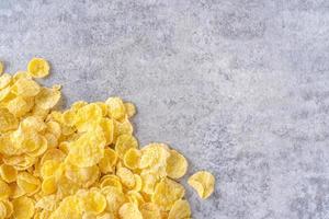 Corn flakes bowl sweets on gray cement background, top view flat lay layout design, fresh and healthy breakfast concept. photo