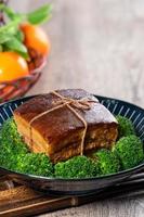 Dong Po Rou Dongpo pork meat in a beautiful blue plate with green broccoli vegetable, traditional festive food for Chinese new year cuisine meal, close up. photo