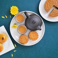 Moon cake for Mid-Autumn Festival, delicious beautiful fresh mooncake on a plate over blue background table, top view, flat lay layout design concept. photo