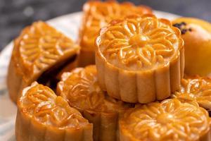 Tasty baked egg yolk pastry moon cake for Mid-Autumn Festival on black slate dark background. Chinese festive food concept, close up, copy space. photo