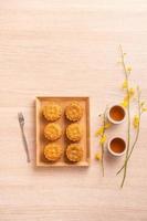 Mid-Autumn Festival holiday concept design of moon cake, mooncakes, tea set on bright wooden table with copy space, top view, flat lay, overhead shot photo