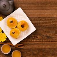 Moon cake for Mid-Autumn Festival, delicious beautiful fresh mooncake on a plate over dark wooden background table, top view, flat lay layout design concept. photo