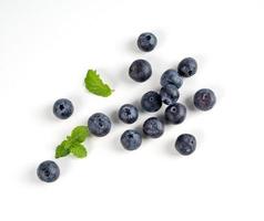 Blueberry fruit top view isolated on a white background, flat lay overhead layout with mint leaf, healthy design concept. photo