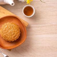 Mid-Autumn Festival holiday concept design of moon cake, mooncakes, tea set on bright wooden table with copy space, top view, flat lay, overhead shot photo