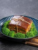 Dong Po Rou Dongpo pork meat in a beautiful plate with green broccoli vegetable, traditional festive food for Chinese new year cuisine meal, close up. photo