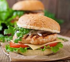 Sandwich with chicken burger, tomatoes, cheese and lettuce photo