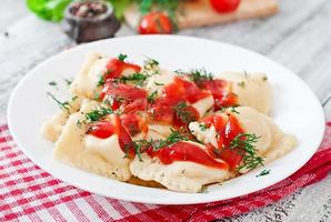 Delicious ravioli with tomato sauce and dill photo