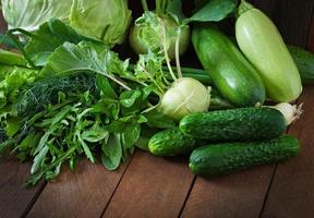 Useful green vegetables on a wooden background photo