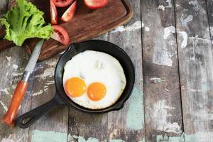 desayuno saludable comida huevo frito en una sartén sobre una mesa de madera.