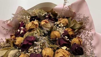 Romantic composition of dried flowers. Dried roses in slow motion on a white background. video