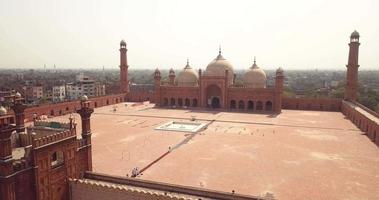 pátio principal da mesquita badshahi com os minaretes em arenito vermelho esculpido com incrustações de mármore, paquistão video