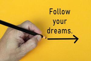 FOLLOW YOUR DREAMS text written on a yellow background. Business concept. photo