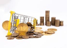 Pay crypto currency  the supermarket cart is filled with gold coins of bitcoin on a white background. Copy space photo