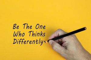 BE THE ONE WHO THINKS DIFFERENTLY text written on a yellow background. Business concept. photo