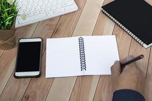 Businessman hands with pen writing notebook on office desk table. Copy space. photo