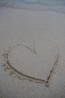 hearts drawn on the sand of a beach photo