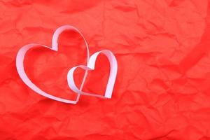 Paper hearts on red background photo