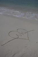 hearts drawn on the sand of a beach photo