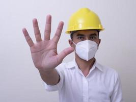 Asian industrial workers wear yellow hard hats, wear protective masks for their health photo