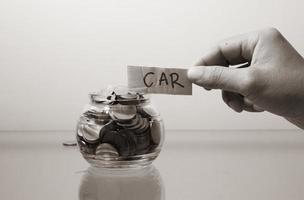 money concept.save money in glass money jar with car label. photo