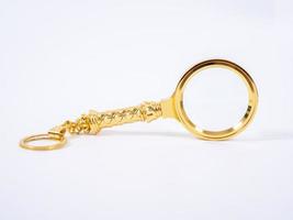 Small Gold Magnifying Glass Isolated on a White Background. photo