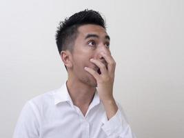 Shocked face of Asian man in white shirt on white background. photo