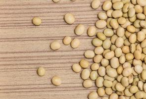 Dry soybeans on wooden board photo